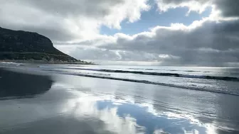 Cape Town Fishermen carrying row boat to shore at Fish Hoek beach