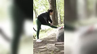 A Woman Stretching Her Legs on a Rock