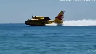 Europe wildfires: Water bomber refills off Spanish beach