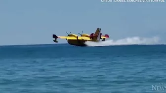 Europe wildfires: Water bomber refills off Spanish beach