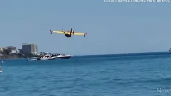 Europe wildfires: Water bomber refills off Spanish beach