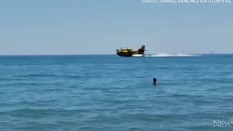 Europe wildfires: Water bomber refills off Spanish beach