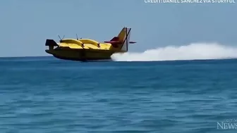 Europe wildfires: Water bomber refills off Spanish beach