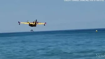 Europe wildfires: Water bomber refills off Spanish beach