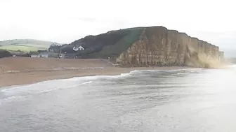 Moment massive chunk of West Bay cliff falls onto beach