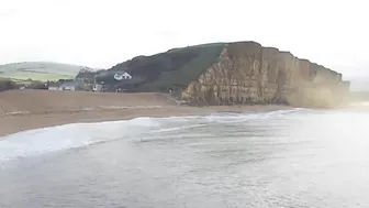 Moment massive chunk of West Bay cliff falls onto beach